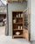 With its sculpted arched pediment, small-paned glass door, and elegantly structured lines, this parisian display cabinet...