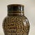 A stunning and solid studio pottery vase in a deep greenish/brown glossy glaze with lighter color accenting the incised,...