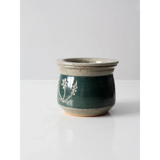This is a vintage studio pottery jar. The hand-crafted ceramic jar features a green and speckled oatmeal glaze. An etched...