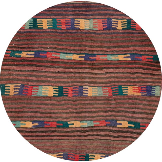 A beautiful hand-woven vintage Kilim rug with a tan field and multi-color accents in an all-over stripe design. This rug...