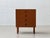 A compact mid-century modern chest of drawers in the clean, functional style of the 1960s, finished in warm teak veneer....
