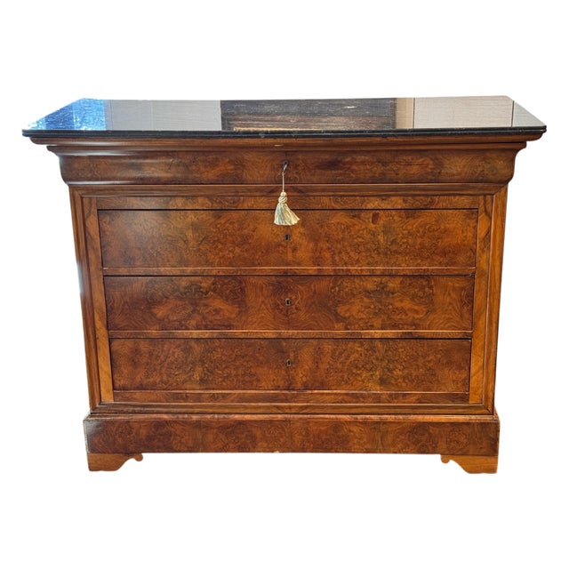 A Louis Philippe chest with a rectangular case fitted with three drawers, shown with a dark stone top with molded edge...