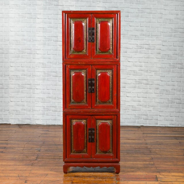 A Chinese red lacquered three-section stackable cabinet from the early 20th century, with polychrome lacquer. Created in...