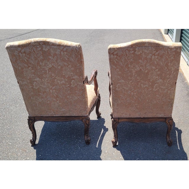 A beautiful pair of Georgian style high back armchairs. Featuring heavily carved frames tall backs upholstered in a blush...
