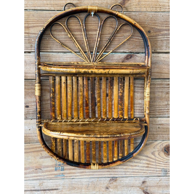 A fabulous pair of vintage coastal rattan Bamboo wall shelves featuring sculptural oval frames, vertical bamboo slats, and...