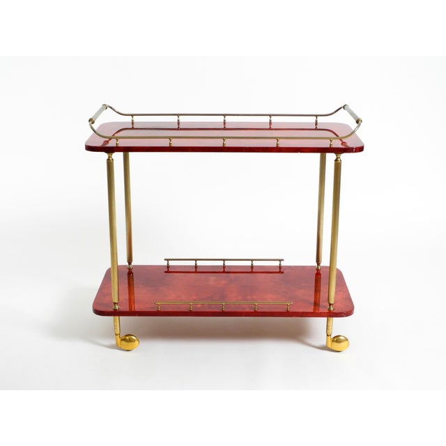 Beautiful 1960s Aldo Tura serving, bar cart made of wood, covered in red goatskin and finished with a thick clear lacquer...