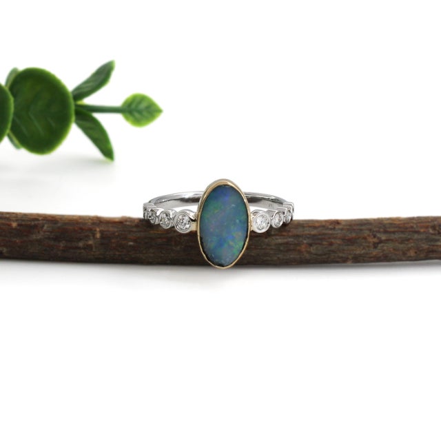 This elegant ring features a captivating 1.13ct fancy-shaped Boulder Opal from Australia, showcasing vibrant natural color...