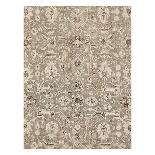 This early 20th-century Persian Tabriz room-size carpet presents a refined allover floral composition across a soft taupe...