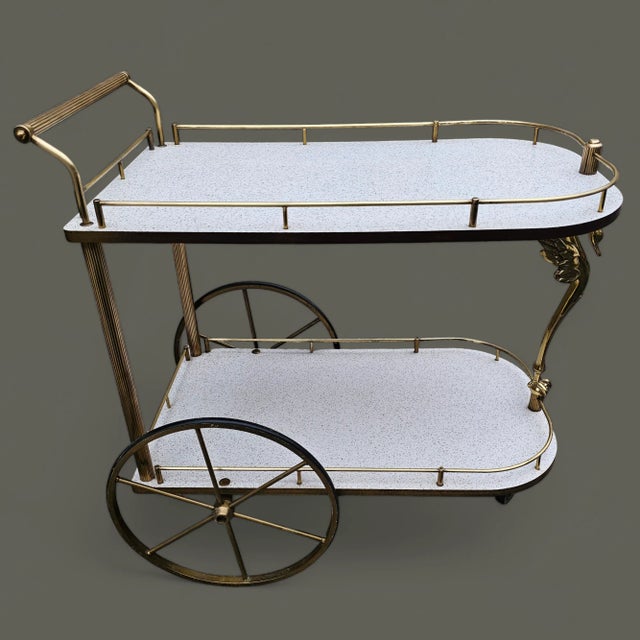 This Mid-Century Hollywood Regency Brass Swan Bar Cart is remarkable, with an elegantly carved brass swan as the...