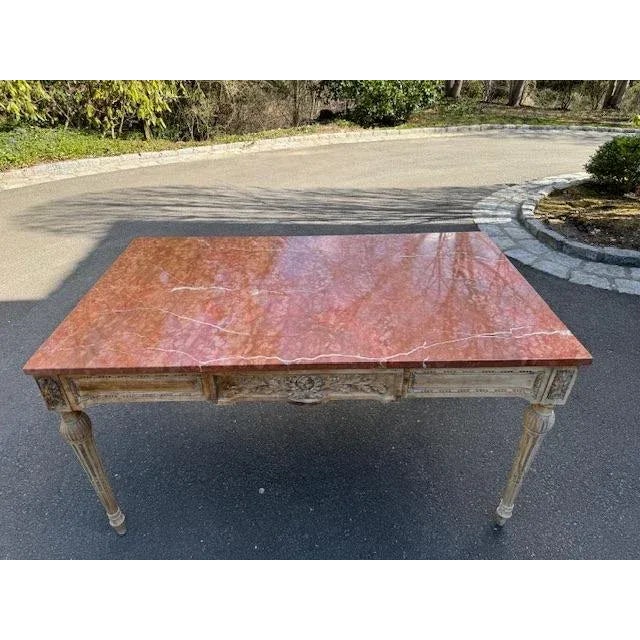 19th century Louis XVI french carved table with rogue marble top. Painted base with very light antique gold accents with...