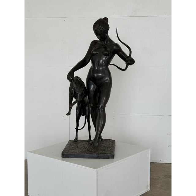 This bronze figure depicts Diana the Huntress standing beside a greyhound, cast in the late 20th century. She is modelled...