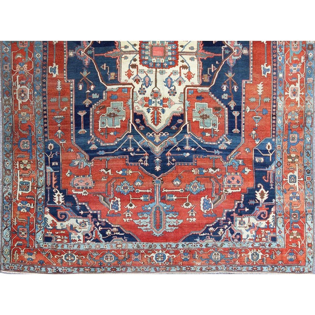 Antique Persian fine weave Serapi rug with large geometric medallion in brilliant colors and blue and tomato red. Keivan...