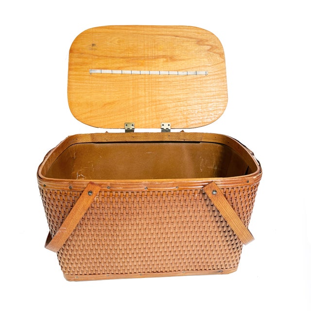 Full of nostalgia and Midwestern idealic mid century charm, this vintage woven picnic basket was crafted by the W.C....