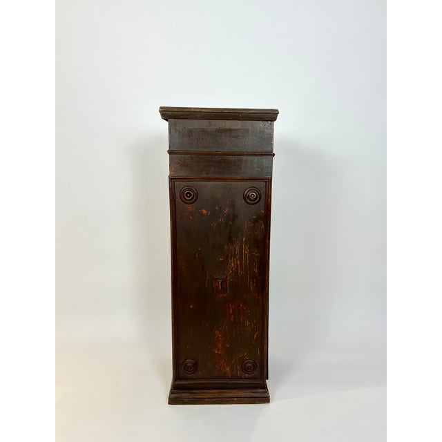 A tall vintage storage plinth, constructed from panelled wood with a concealed door to the side. Salvaged from an old...