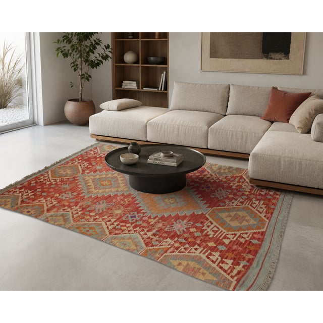Authentic hand-woven Afghan wool kilim featuring a refined traditional geometric design and a vibrant color palette of...