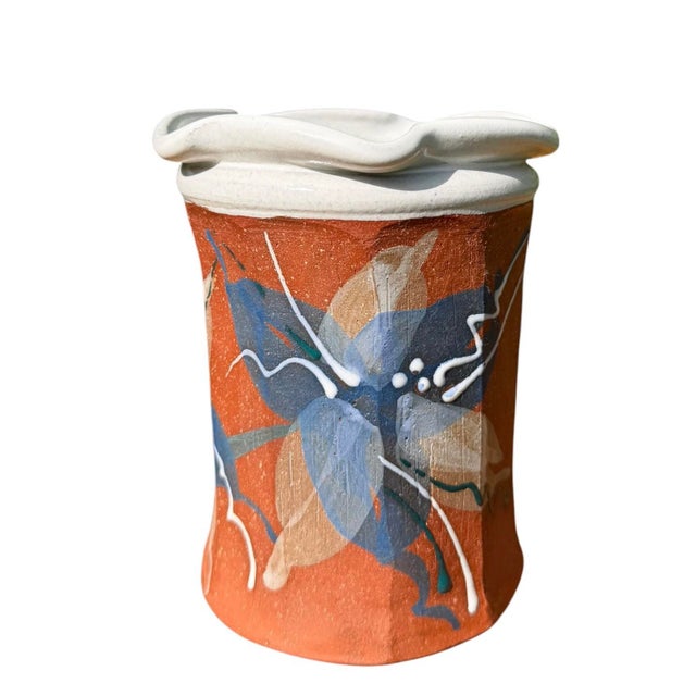 A signed handmade terracotta studio pottery vase featuring a sculptural undulating rim and hand-painted abstract botanical...
