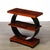 This striking Art Deco Machine Age 3-Tier Walnut Side Table w/ Black Lacquer Round Support originated in the United...