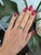 A Colombian emerald glows in vivid, slightly bluish green at the centre of this solid 14K yellow gold ring, flanked by two...