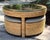 Round woven wicker coffee/game table set with matching nesting stools or wedge ottomans in a blue stripe performance...