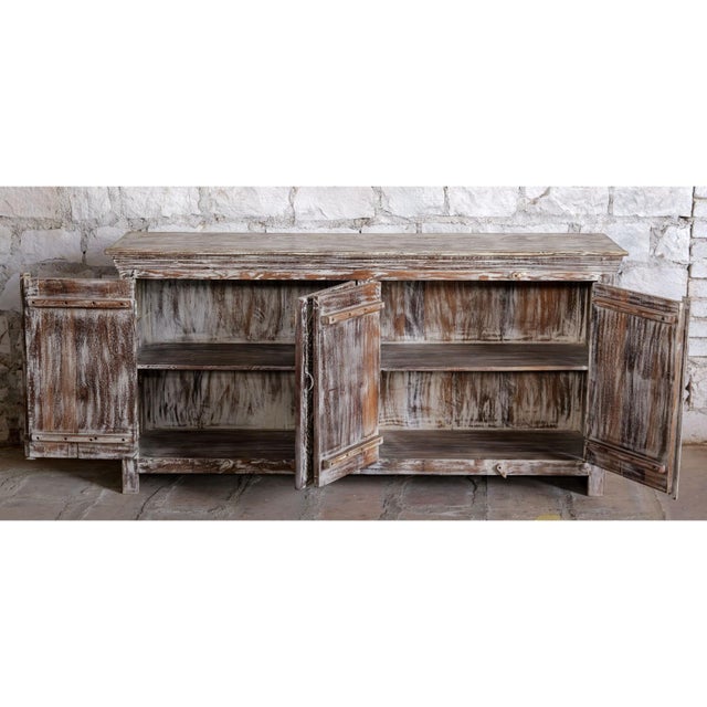 This antique whitewashed sideboard is a stunning blend of rustic elegance and artisanal craftsmanship. Adorned with...
