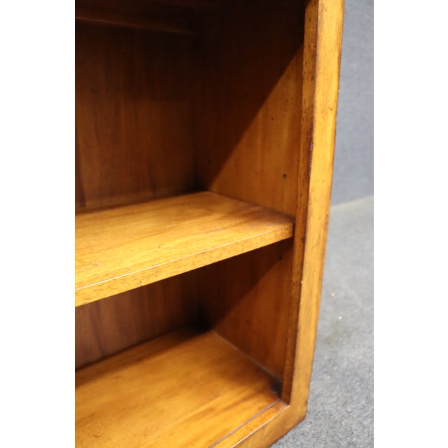 Ethan Allen low bookcase crafted in cherry with a warm golden-brown finish. Features a simple rectangular form with two...