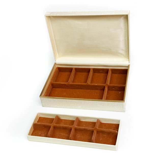 Store your accessories in they with this 1960s chic jewelry box. It is rectangular in shape with a silky cream fabric...