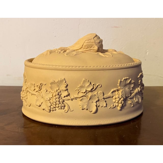 Wedgwood caneware vegetable tureen and cover. Decorated with relief molded grapevine pattern and a foliate knop with...