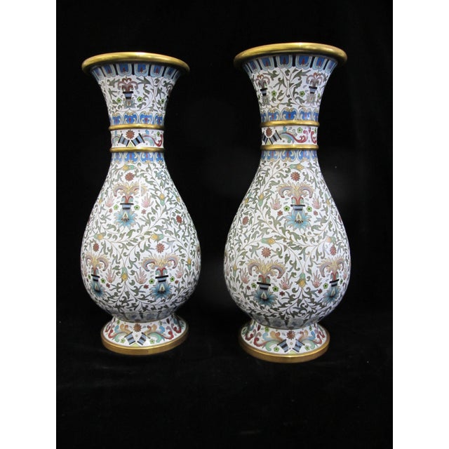 Pair of Chinese cloisonné 20th century vases. Enamel on brass, showing white ground adorned with bands of colorful flowers...