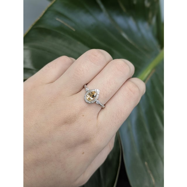 This elegant ring features a 0.8-carat pear-shaped Imperial Topaz from Brazil, measuring 2x4.8mm. Known for its warm,...