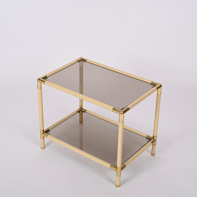 Gorgeous Mid-Century rectangular cocktail table in enameled metal and brass with smoked glasses. This wonderful object was...