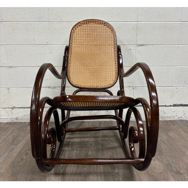 This is a beautiful vintage Thonet-style bentwood rocking chair featuring a dark stained beechwood frame, dramatic double-...