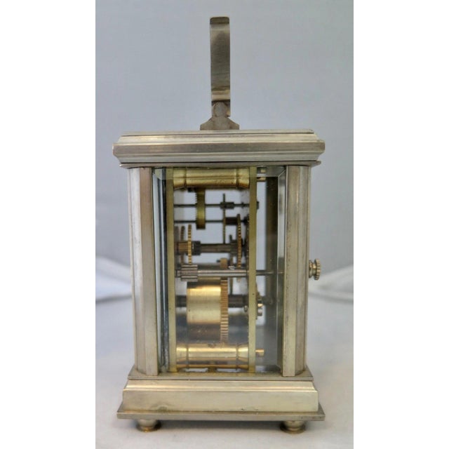 This charming vintage carriage clock dates from the early 20th century. The footed clock with nickel plated brass housing...