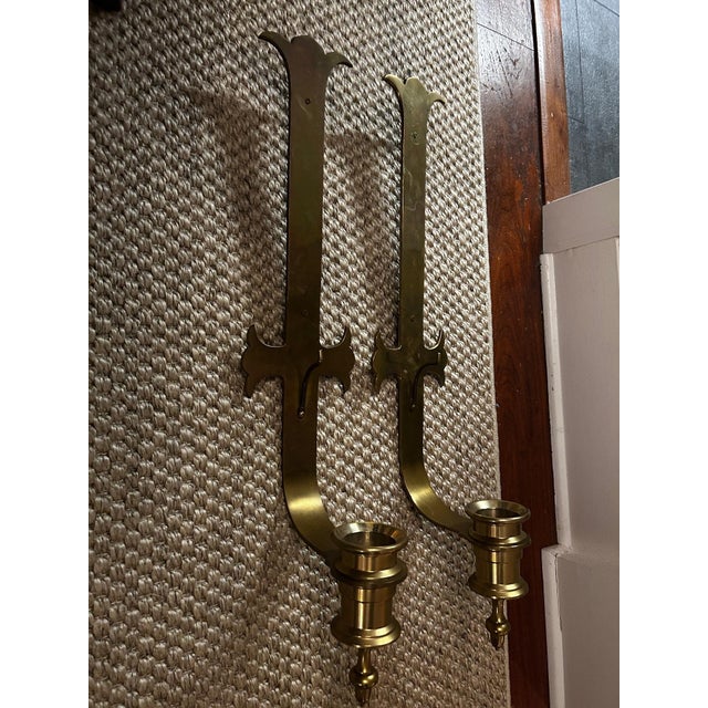 Pair of very large solid brass sconces for candles by Chapman marked 1972 in a Gothic style. Each measures 29” long and 6”...