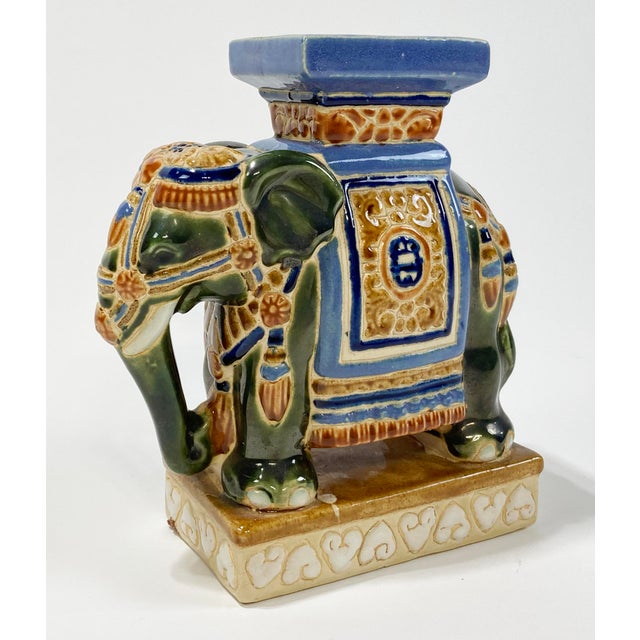 Deep colors of green, blue and browns adorn this vintage ceramic elephant stand, bookend, or decorative piece. Natural age...