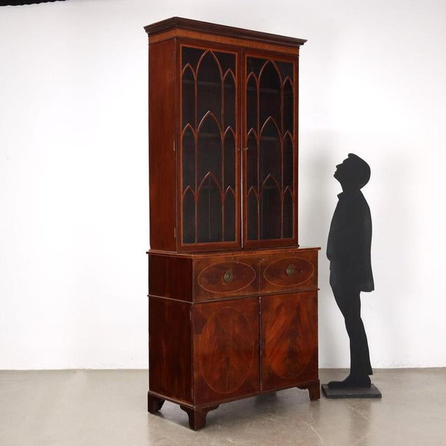 Neo-Gothic style bookcase in mahogany, interior in oak and fir. Central drop-leaf drawer concealing internal cabinet with...