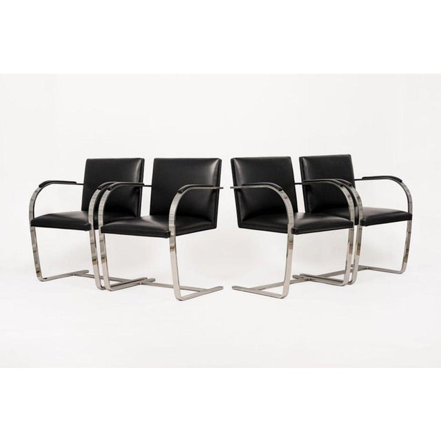 This set of four mid century modern Brno arm chairs by Mies van der Rohe were manufactured by Knoll circa 2015. These...