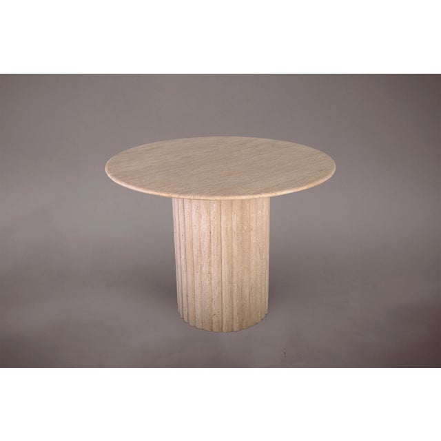 Introducing our exquisite Round Travertine Table, featuring vertically striped edges and a single conical leg....