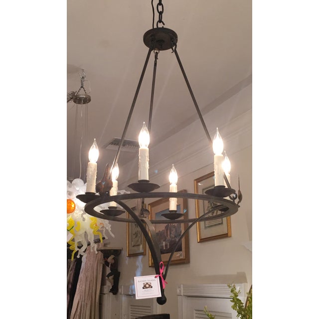 This lovely chandelier is a genuine designer original in hand wrought iron. It features 6 lights and is in new condition....