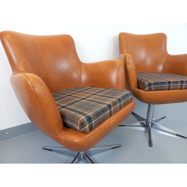 Continuation of 2 vintage armchairs from the 70s, type Egg armchairs or hull armchairs, in cognac skai, central foot with...