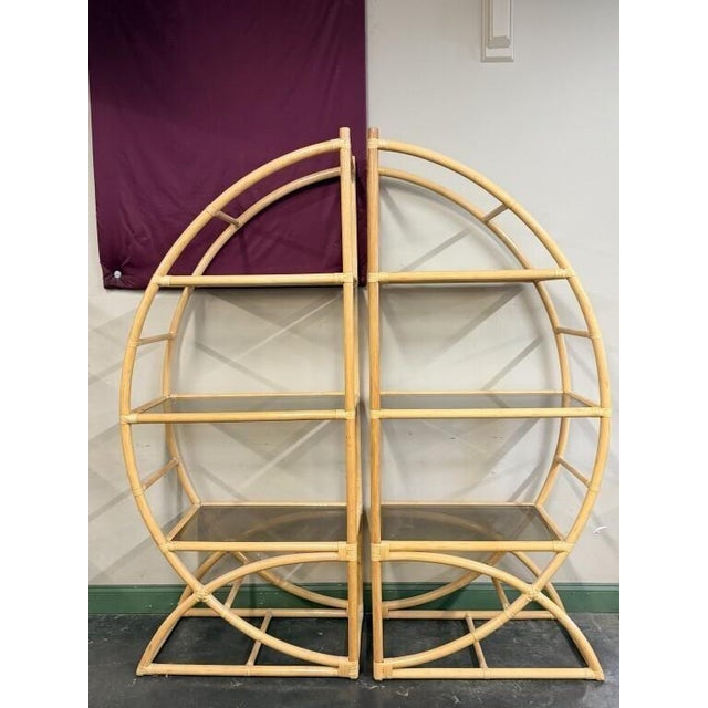A sculptural pair of seven-foot-tall rattan etageres with rounded open frames, wrapped joints, and three smoked-glass...
