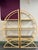 A sculptural pair of seven-foot-tall rattan etageres with rounded open frames, wrapped joints, and three smoked-glass...