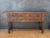 Spanish Renaissance Revival console table featuring four carved drawers and distinctive spiral turned front legs. The...
