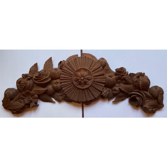 A solid oak, densely carved pediment with a central sunburst surrounded by pomegranates, roses, apples, a daisy, and...