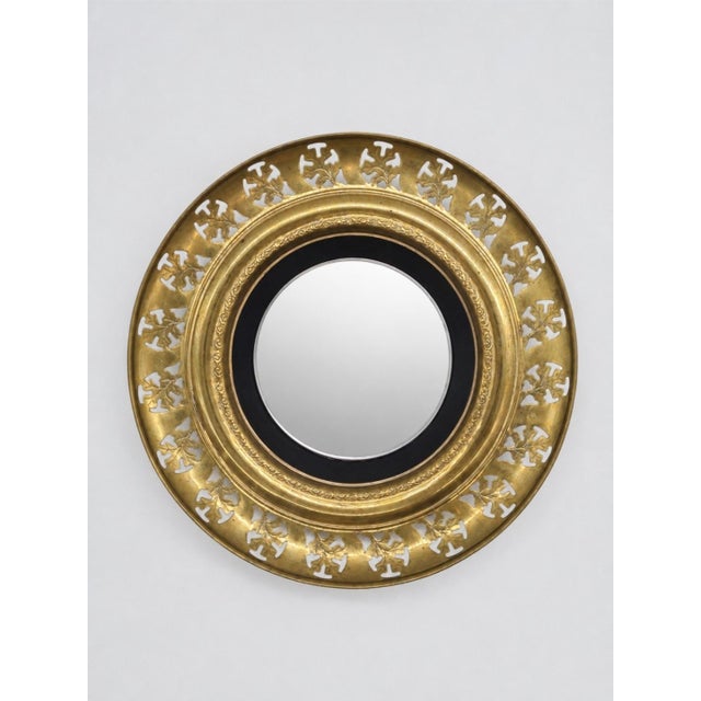 An elegant decorative wall mirror in an openwork brass frame inspired by the Regency style. This model features a classic...
