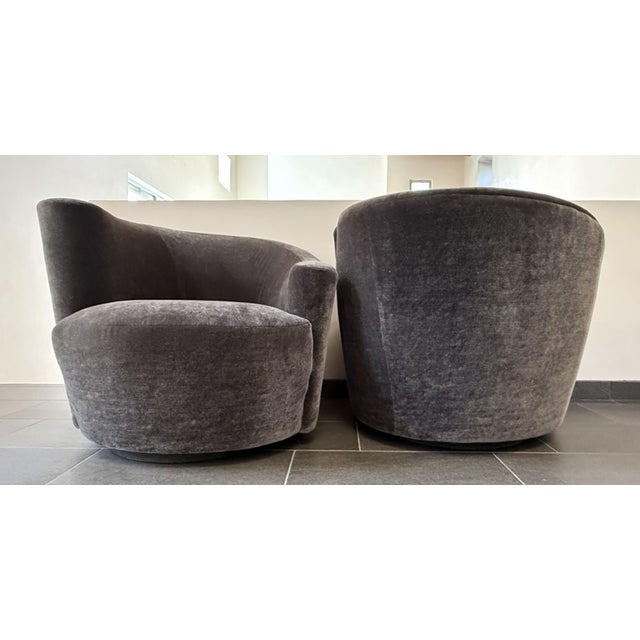 A sculptural pair of 1970s swivel lounge chairs by Weiman, executed in the manner of Vladimir Kagan and defined by a...