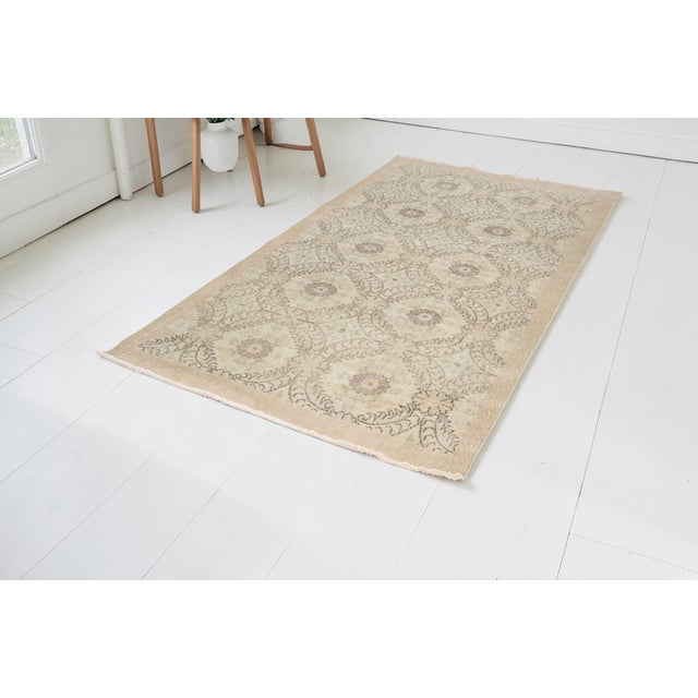 This is a vintage Turkish Oushak rug from the Mid 20th Century. The piece was hand-knotted.