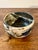 A striking 1984 American studio pottery bowl featuring a complex, painterly glaze in layered whites, deep blues, blacks,...