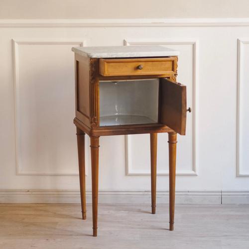 An elegant French bedside table, circa 1890, with a fine gray marble top. Subtly tapered legs and the interior, featuring...