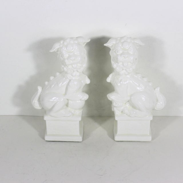 This is a pair of vintage Chinese Foo dogs. They are made from white ceramic with a white glaze and a slight cream tinge....