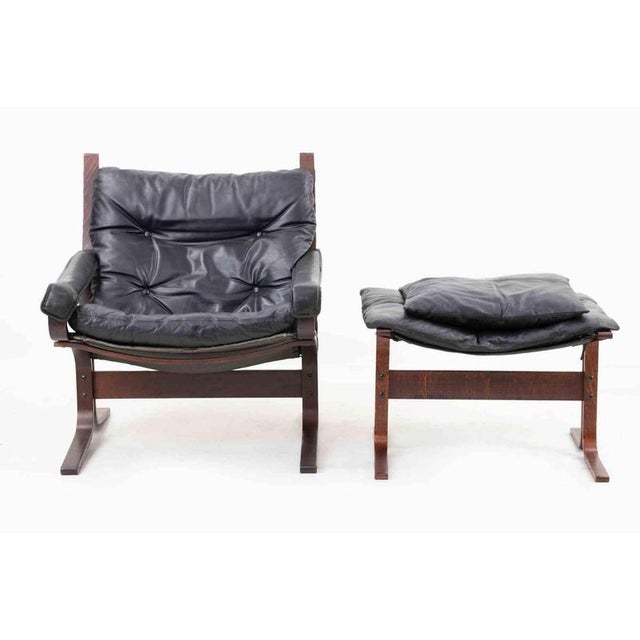 Vintage "Siesta" Armchair with footstool and cushion. Laminated beech wood, stained and lacquered, black canvas on rear...